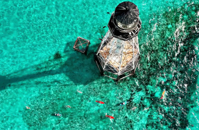 Swimmers are escorted by kayakers as they circle Alligator Reef Lighthouse during last year’s Swim for Alligator Lighthouse open-water challenge off Islamorada, Fla., in the Florida Keys.  – Bob Care / Florida Keys News Bureau